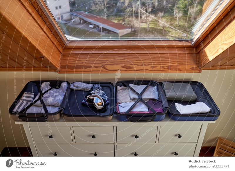 Kofferpaket für den Winterurlaub Gepäck Bekleidung reisen Vorbereitung offen Kommode Fenster heimwärts gemütlich Hut Schutzbrille Ausflug Kleidung