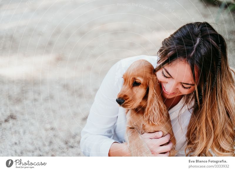 junge Frau und ihr süßer Cockerspaniel-Welpe im Freien in einem Park Hund Haustier Sonnenstrahlen Außenaufnahme Liebe Umarmen Lächeln Rückansicht Küssen züchten