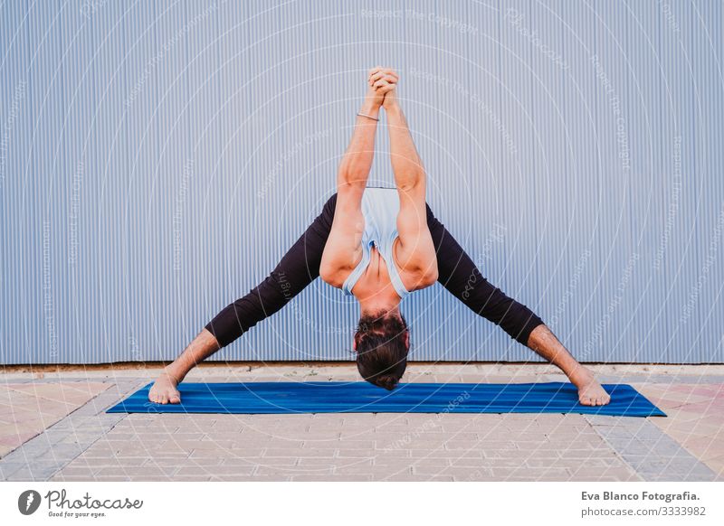 mann in der stadt, der yoga-sport betreibt. blauer hintergrund. gesunde lebensweise Blauer Hintergrund Yoga Mann Großstadt Stadt Lifestyle muskulös