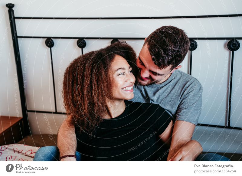 glückliches, verliebtes Paar zu Hause. Afroamerikanische Frau und kaukasischer Mann. ethnisches Liebeskonzept Afroamerikaner urwüchsig heimwärts Bett