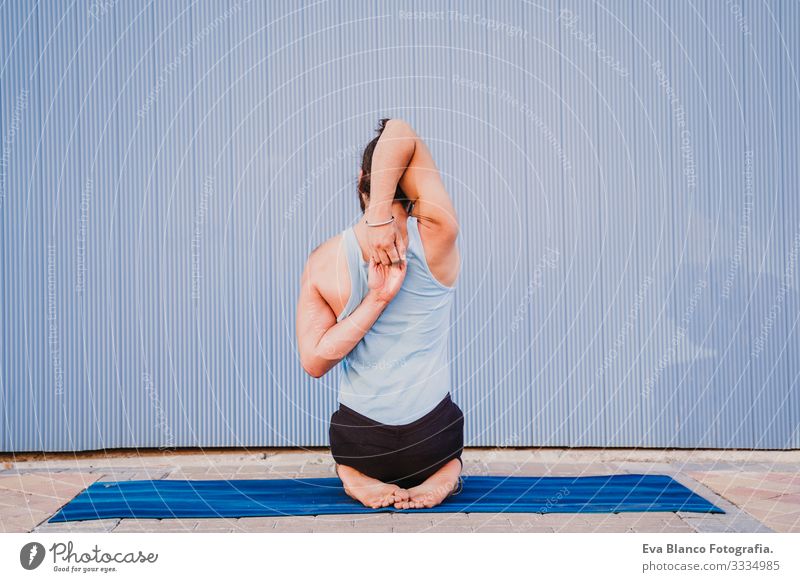 mann in der stadt, der yoga-sport betreibt. blauer hintergrund. gesunde lebensweise Yoga Mann Sport Gesundheit Außenaufnahme Großstadt Blauer Hintergrund