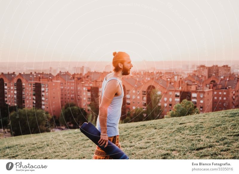 junger Mann in einem Park, der bereit ist, Yogasport zu betreiben. Jugendliche Sport Großstadt Sonnenuntergang Lifestyle Gesundheit Unterlage Sportkleidung