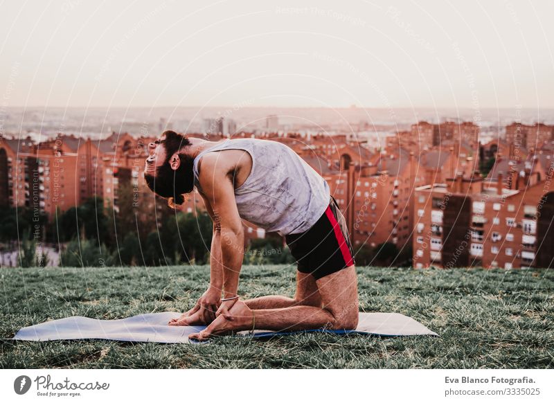 junger Mann in einem Park, der Yoga-Sport betreibt. Stadthintergrund. gesunde Lebensweise. Jugendliche Großstadt Sonnenuntergang Lifestyle Gesundheit Unterlage