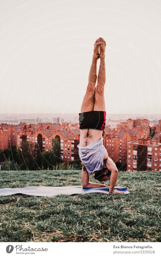 junger Mann in einem Park, der Yoga-Sport betreibt. Stadthintergrund. gesunde Lebensweise. Jugendliche Großstadt Sonnenuntergang Lifestyle Gesundheit Unterlage