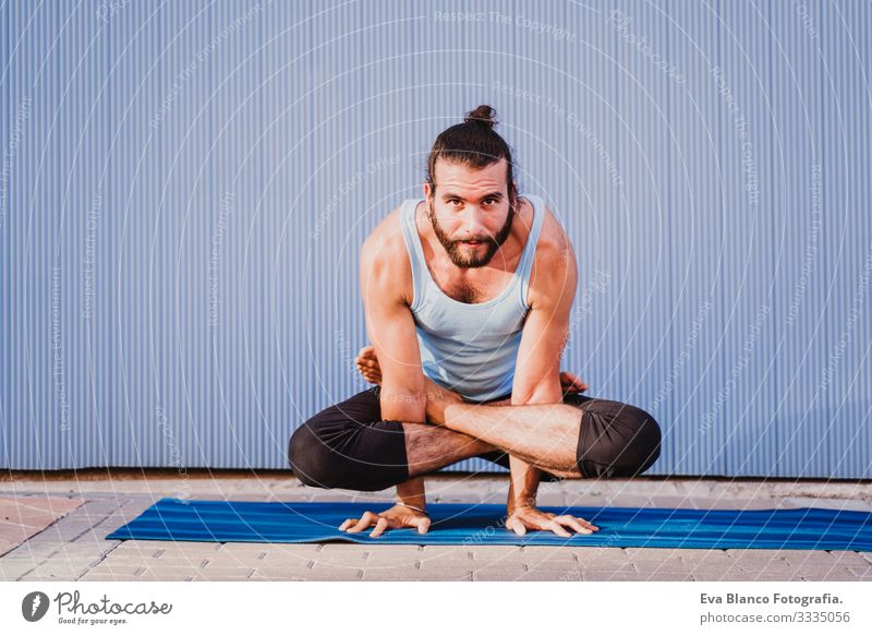 mann in der stadt, der yoga-sport betreibt. blauer hintergrund. gesunde lebensweise Yoga Mann Sport Gesundheit Außenaufnahme Großstadt Blauer Hintergrund