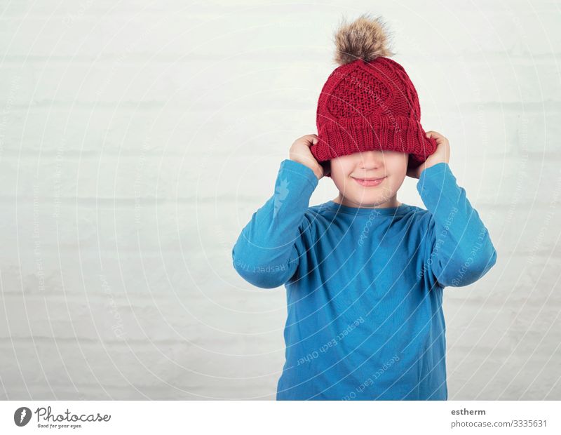 lustiges Kind mit Winterhut Lifestyle Freude Freizeit & Hobby Mensch maskulin Kleinkind Kindheit 1 8-13 Jahre Wetter Hut festhalten Lächeln Fröhlichkeit Gefühle