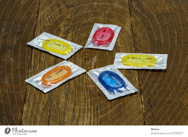Packungen mit bunten Kondomen liegen auf einem Holztisch mehrfarbig Produkt Gummi Schutz Mensch Farbe Ferien & Urlaub & Reisen AIDS Gesundheit Gesundheitswesen