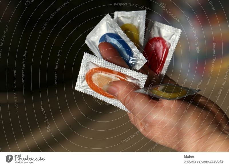Volle Hand mit farbigen Kondomen Packung Farbe AIDS Schutz Sicherheit Sex Sexualität Familienplanung Verhütungsmittel Latex gefährlich Risiko Kontrolle