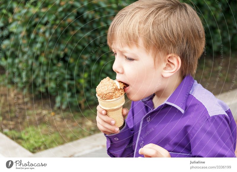 Blonder Junge isst Eiscreme mit herausgestreckter Zunge Speiseeis Essen Freizeit & Hobby Kind Schulkind Mensch Baby Mann Erwachsene Kindheit Park Spielplatz