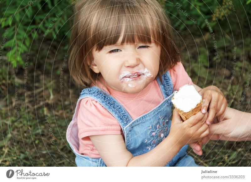 Lächelndes, süßes Mädchen essen Eiscreme Speiseeis Süßwaren Essen Kind Baby Frau Erwachsene Park blond weiß Europäer Kaukasier eine zwei drei Dame kurz