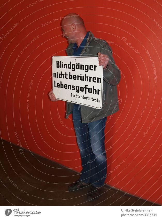 Mann hält Schild mit "Blindgänger" Mensch maskulin Erwachsene Leben 1 45-60 Jahre Schriftzeichen Schilder & Markierungen Lächeln lachen stehen warten
