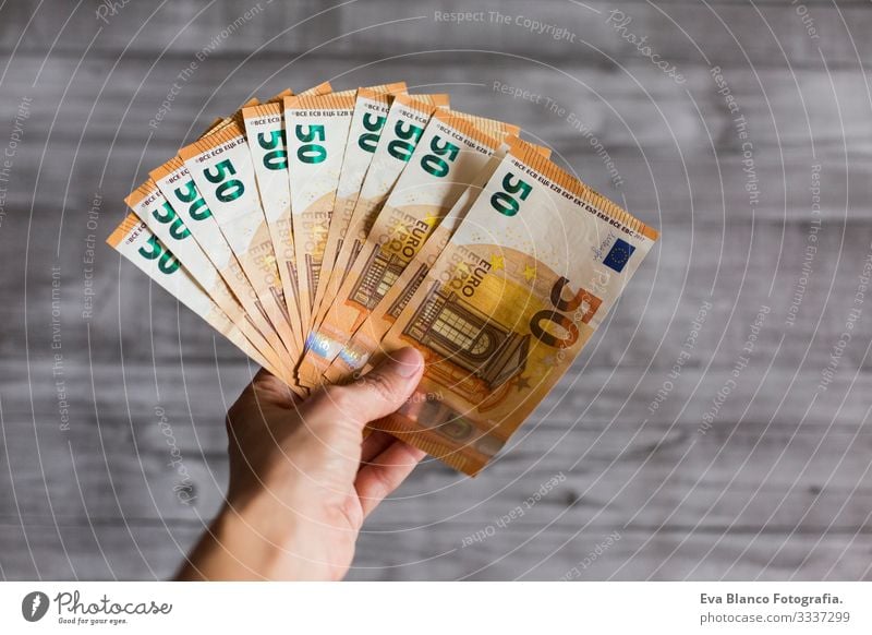 Frau hält isoliert auf grauem Holzuntergrund Bargeld in der Hand. Fünfzig Euro-Scheine. Europäer Geld Europa fünfzig Vermögen Halt Zahlung finanziell