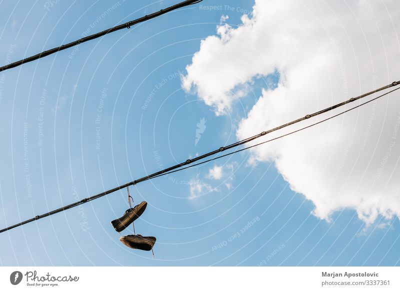 Alte Schuhe, die an den Schnürsenkeln am Himmel hängen Wolken Kleinstadt Stadt hoch Neugier Zukunftsangst Unglaube Freiheit Frustration Idee Inspiration