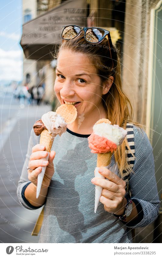 Junge Frau hält zwei Eiscremes auf der Straße Speiseeis Fastfood Lifestyle Freude Ferien & Urlaub & Reisen Tourismus Ausflug Mensch feminin Jugendliche