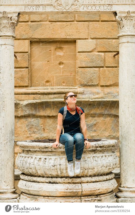 Junge Frau sitzt auf einem Brunnen in der Altstadt der Toskana Lifestyle Ferien & Urlaub & Reisen Tourismus Ausflug Sightseeing Städtereise Mensch feminin