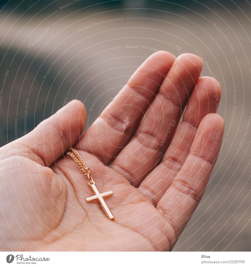 Eine Person hält ein goldenes Kruzifix in der Hand. Glaube und Christentum. Mensch 1 Religion & Glaube Christliches Kreuz Katholizismus Protestantismus Kette