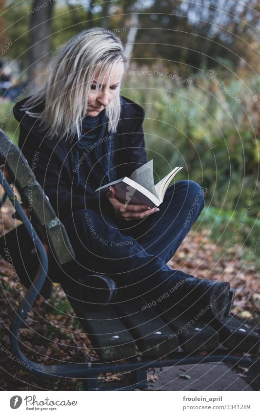 UT HH 19 | junge Frau liest ein Buch auf der Parkbank 1 Person Außenaufnahme Bank Bildung Hochformat Jacke Tageslicht bilden blond entspannen lange Haare lesen
