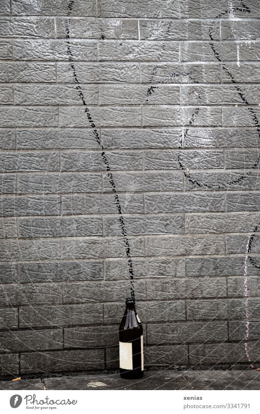 Bierflasche an der Wand mit schwungvollem Bogen Flasche Getränk Alkohol Stadt Mauer Fassade Schriftzeichen Graffiti dreckig trashig braun grau schwarz