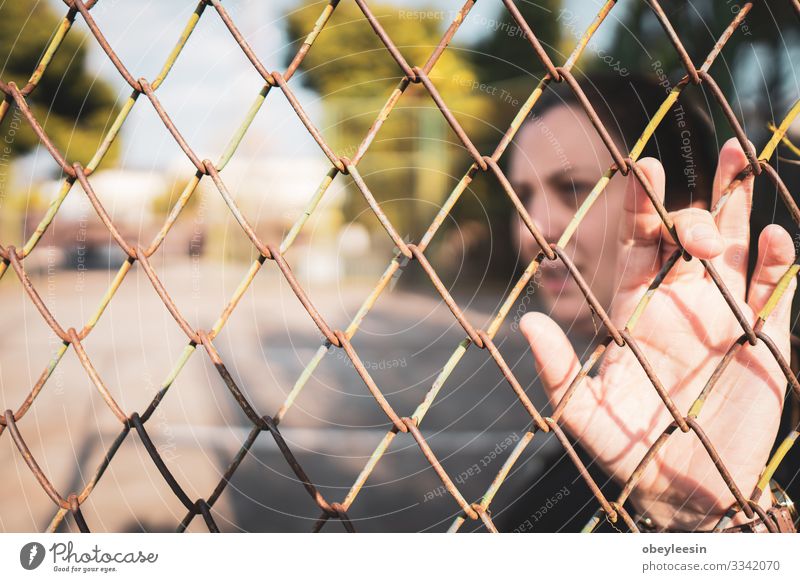 Frau, die hinter einem Zaun steht und sich gefangen und allein fühlt schön Erwachsene Umwelt Denken Einsamkeit Fürsorge ruhig Außenaufnahme früher Morgen