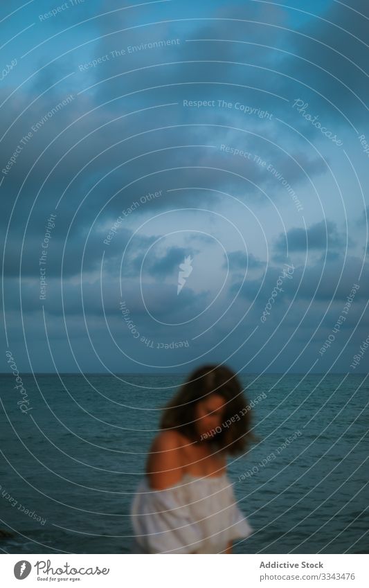 Weibliche Touristen am Meer Frau Strand Wellen Seeküste Meeresufer Himmel Himmel (Jenseits) Abenddämmerung Wolken Dame laufen Küstenlinie leer einsam blau Kleid