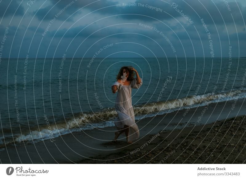 Weibliche Touristen am Meer Frau Strand Wellen Seeküste Barfuß Meeresufer Himmel Himmel (Jenseits) Abenddämmerung Wolken Dame laufen Küstenlinie leer einsam