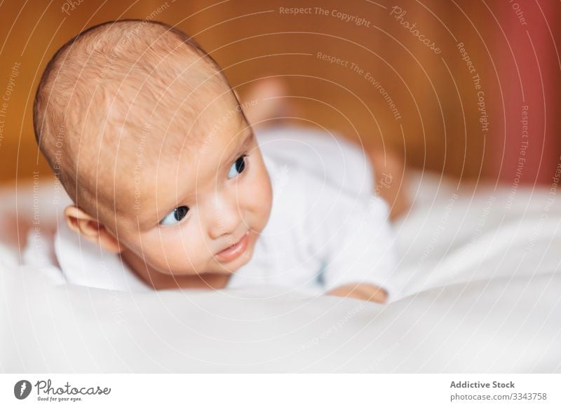 Liebliches Neugeborenes im Bett liegend Baby Lügen neugeboren heimwärts Säugling lieblich bezaubernd Kind Windstille klein niedlich süß Porträt Pyjama lässig