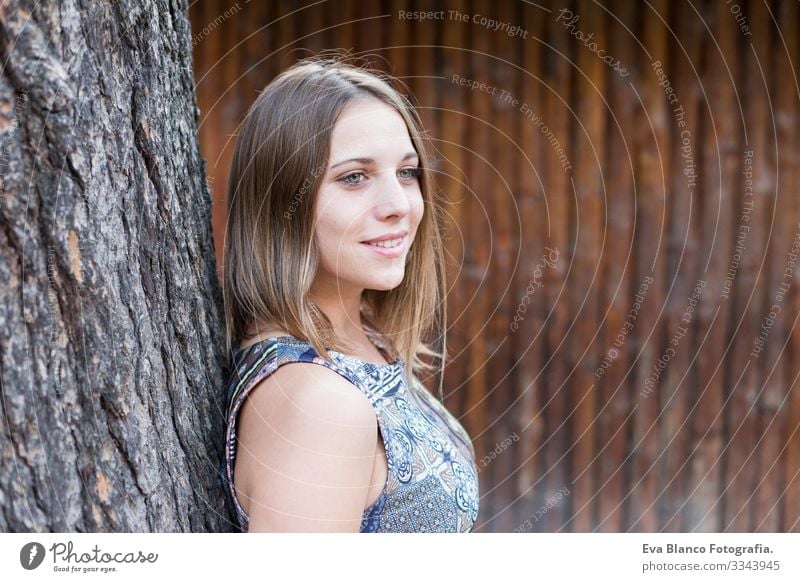 das Porträt einer schönen jungen Frau im Freien, die in die Kamera schaut und lächelt. Holz-Hintergrund Jugendliche Glück Mädchen Lifestyle Beautyfotografie