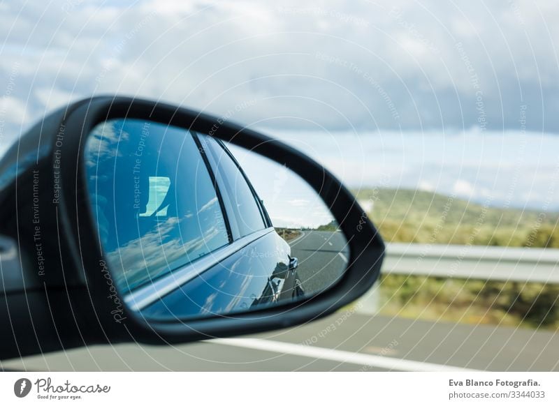 Auto auf der Straße mit bewegungsunscharfem Hintergrund und Rückspiegel. Reisekonzept. Bewölkter Himmel Geschwindigkeit Unschärfe hell Spiegel modern Zukunft