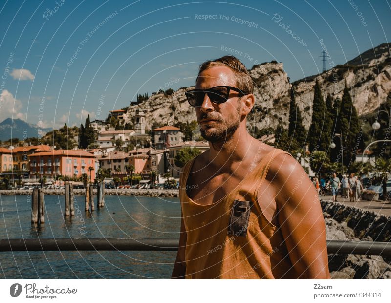 Junger Mann im Urlaub | Torbole Gardasee gardasee mann strand torbole seeufer berge Berge u. Gebirge Außenaufnahme Wasser Italien Natur Landschaft Sommer hafen