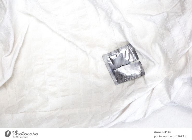 Eine offene Kondomverpackung auf weißen Bettlaken, Verhütungsmittel Lifestyle Medikament Leben Mann Erwachsene Rudel Verpackung Paket Liebe Sex Sauberkeit