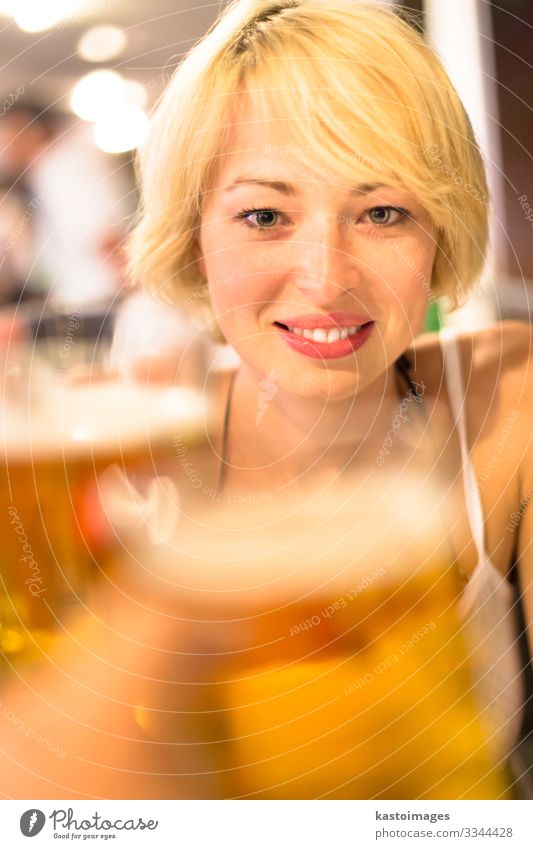 Eine Dame stößt mit einem Bier an. Getränk Alkohol Lifestyle Freude Erholung Freizeit & Hobby Nachtleben Flirten Feste & Feiern Mensch Frau Erwachsene