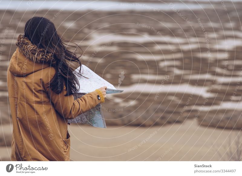 Frau liest eine Karte neben einem Fluss, Griechenland. schön Erholung Freizeit & Hobby Abenteuer Meer Winter wandern Mensch Erwachsene Hand Natur Wind Küste See