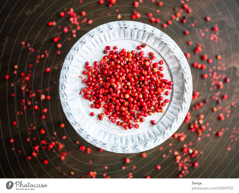 Roter getrockneter Pfeffer auf einem silbernen Teller Lebensmittel Kräuter & Gewürze Pfefferkörner rot Bioprodukte Gesundheit Holztisch Duft genießen