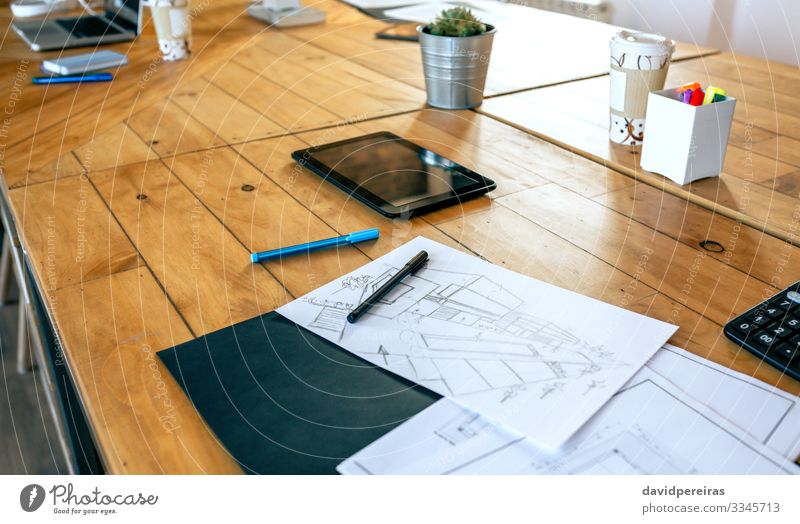 Arbeitsplatz eines Architekten mit Blaupausen und Skizzen Design Dekoration & Verzierung Schreibtisch Tisch Büro Business Notebook Pflanze Architektur