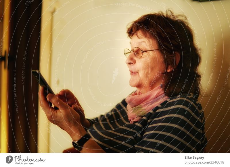 Geübter Blick ins Handy Mensch feminin Frau Erwachsene Weiblicher Senior Freundschaft 1 60 und älter entdecken lesen lernen Telefongespräch natürlich blau