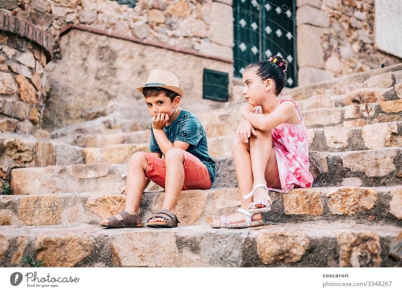 Zwei gelangweilte Kinder, die an einem Sommertag auf einer Treppe sitzen Lifestyle Gesicht Freizeit & Hobby Ferien & Urlaub & Reisen Sommerurlaub Garten Mensch