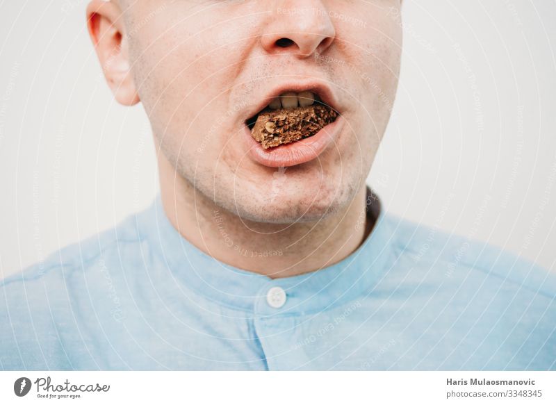 Mann isst Schokolade aus nächster Nähe Lebensmittel Essen Diät füttern Bonbon Keks Kalorie Mund Farbfoto Innenaufnahme Studioaufnahme Textfreiraum links