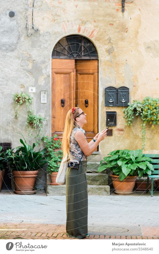 Junge Frau in der italienischen Altstadt Lifestyle Freude Ferien & Urlaub & Reisen Tourismus Ausflug Sightseeing Städtereise Handy Fotokamera Mensch feminin