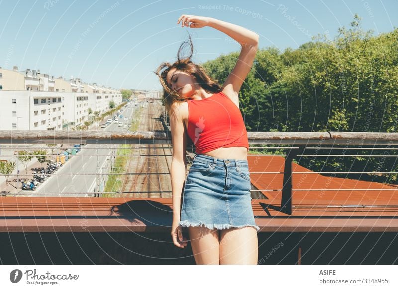 Junge schöne Frau beim Sonnenbaden auf einer Brücke über die Stadt Lifestyle Freude Glück Erholung Freizeit & Hobby Sommer Erwachsene Arme Natur Wind Baum Park