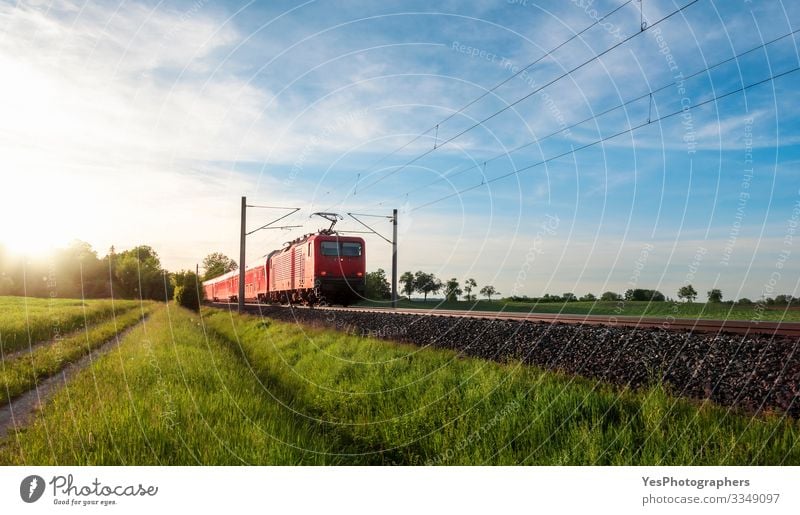 Roter Zug fährt in einer Sommerlandschaft. Zug in der Natur Ferien & Urlaub & Reisen Sonne Landschaft Schönes Wetter Gras Wiese Verkehr Verkehrsmittel