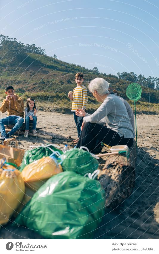 Freiwillige, die sich nach der Reinigung des Strandes ausruhen Essen trinken Kaffee Meer Kind sprechen Mensch Junge Frau Erwachsene Mann