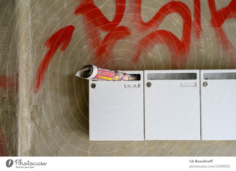 Briefkästen und Wand mit Graffiti Hochhaus Gebäude Mauer Briefkasten Beton Zeichen braun weiß Zerstörung Farbfoto Tag