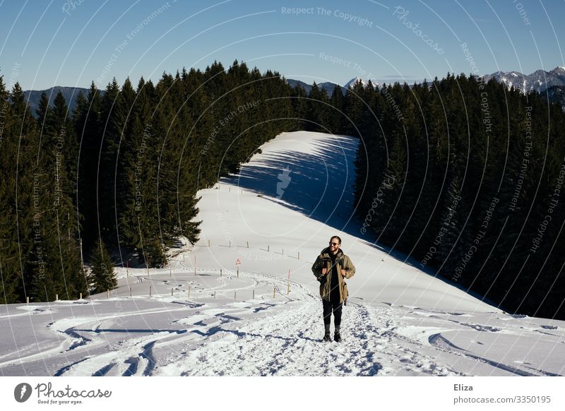 Ein Mann beim Wandern in den Bergen im Winter mit viel Schnee Schneelandschaft Hang blauer Himmel Sonnenschein Berge u. Gebirge Natur Ausflug Bayern
