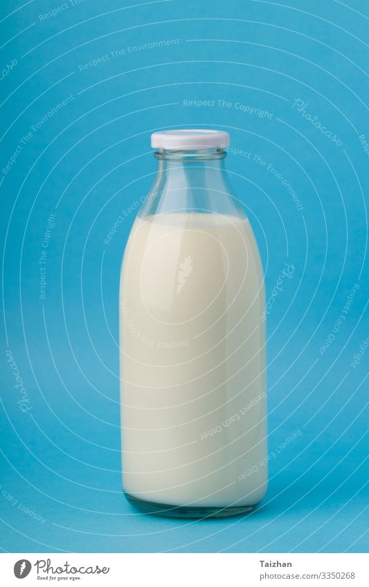 Milch in Glasflasche auf blauem Hintergrund. close-up Frühstück Getränk Flasche Lifestyle Natur Container Kuh Coolness frisch natürlich Sauberkeit weiß Farbe