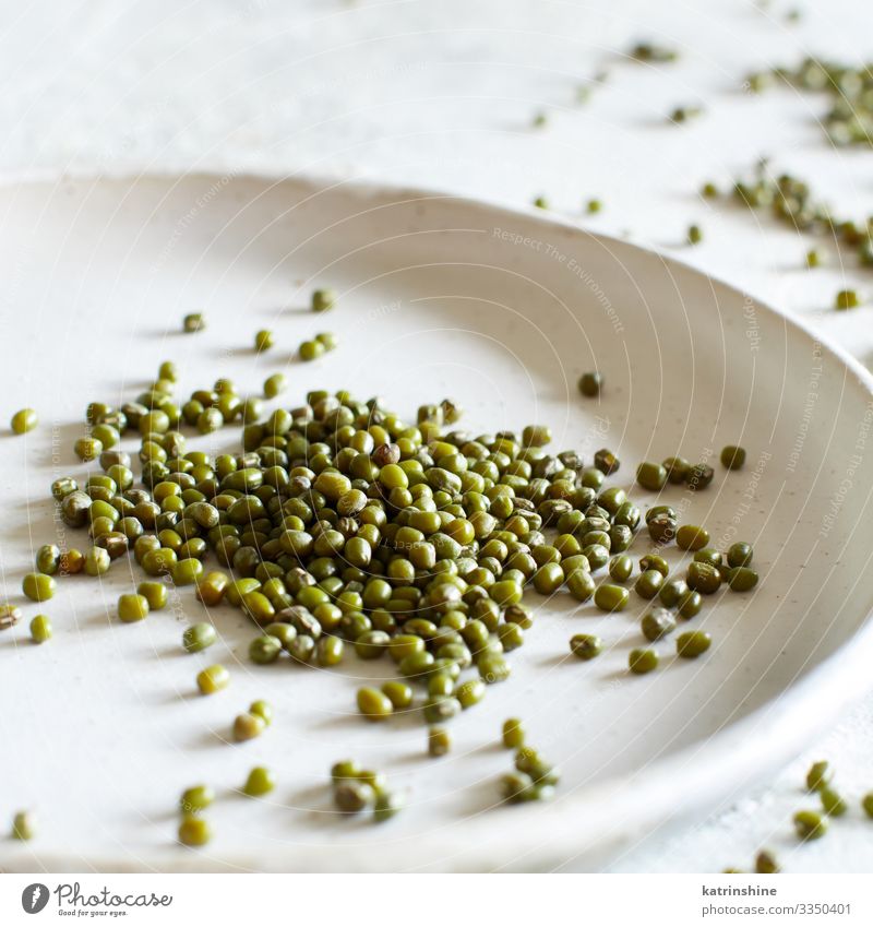 Getrocknete Mungbohnen auf einer Keramikplatte Vegetarische Ernährung Diät Teller Tisch grün weiß Bohnen mung Murmel getrocknet Sehne Lebensmittel Gesundheit