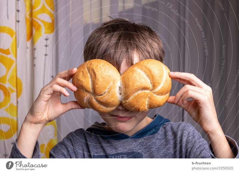 Kind mit hält zwei Brötchen vor die Augen Lebensmittel Brot Ernährung Essen Gesunde Ernährung Spielen Gesicht Hand 1 Mensch Brille wählen festhalten Duft