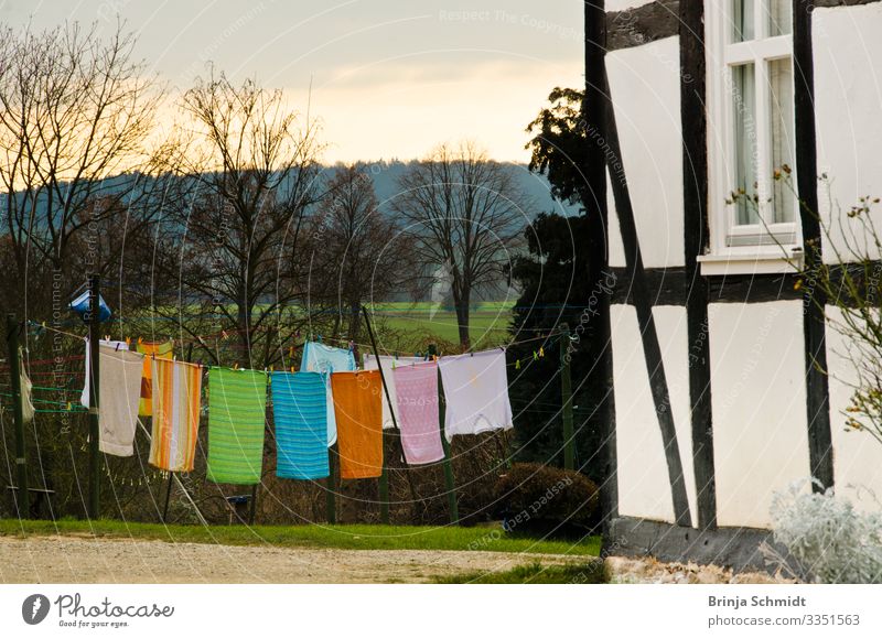 Bunte Handtücher trocknen an einer Wäscheleine Garten Landschaft Frühling Wetter Fachwerkhaus Stoff Wind hängen schaukeln alt frisch Glück schön einzigartig