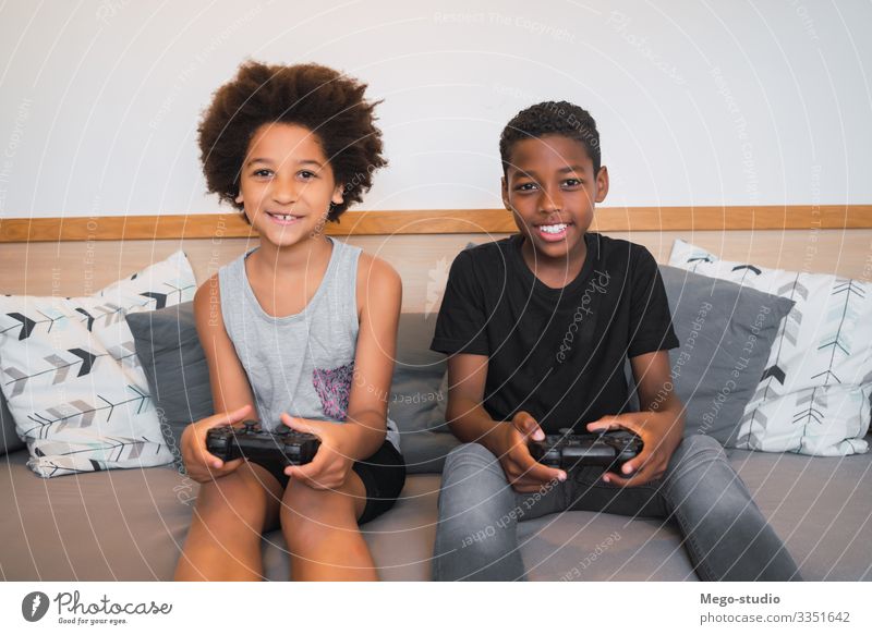 Zwei Brüder spielen zu Hause Videospiele. Lifestyle Freude Glück Freizeit & Hobby Spielen Sofa Entertainment Kind Technik & Technologie Mensch Junge