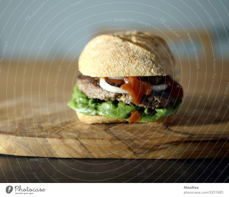 Hamburger- Sandwich mit Brötchen Lebensmittel Fleisch Salat Salatbeilage Teigwaren Backwaren Belegtes Brot Zwiebel Hackfleisch Beef Rindfleisch Holzbrett