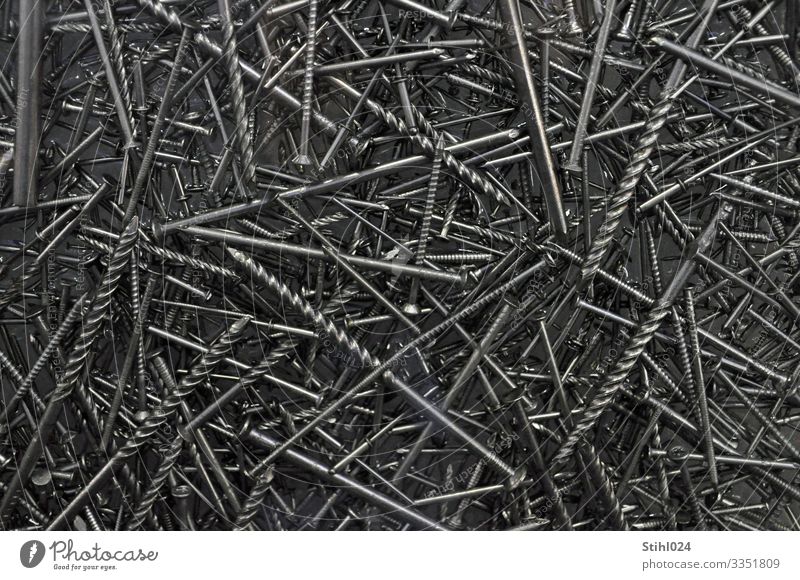 viele verschiedene Nägel liegen durcheinander heimwerken Handwerk Nagel Schraubnagel Metall grau schwarz silber Spitze gerade Stahl chaotisch Durchmesser